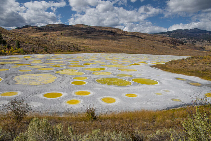 Visit Spotted Lake in British Columbia, Canada and experience its unique beauty. The lake is made up of a variety of minerals that form colorful spots when the water evaporates. Explore the area and learn about its history and significance to the local First Nations