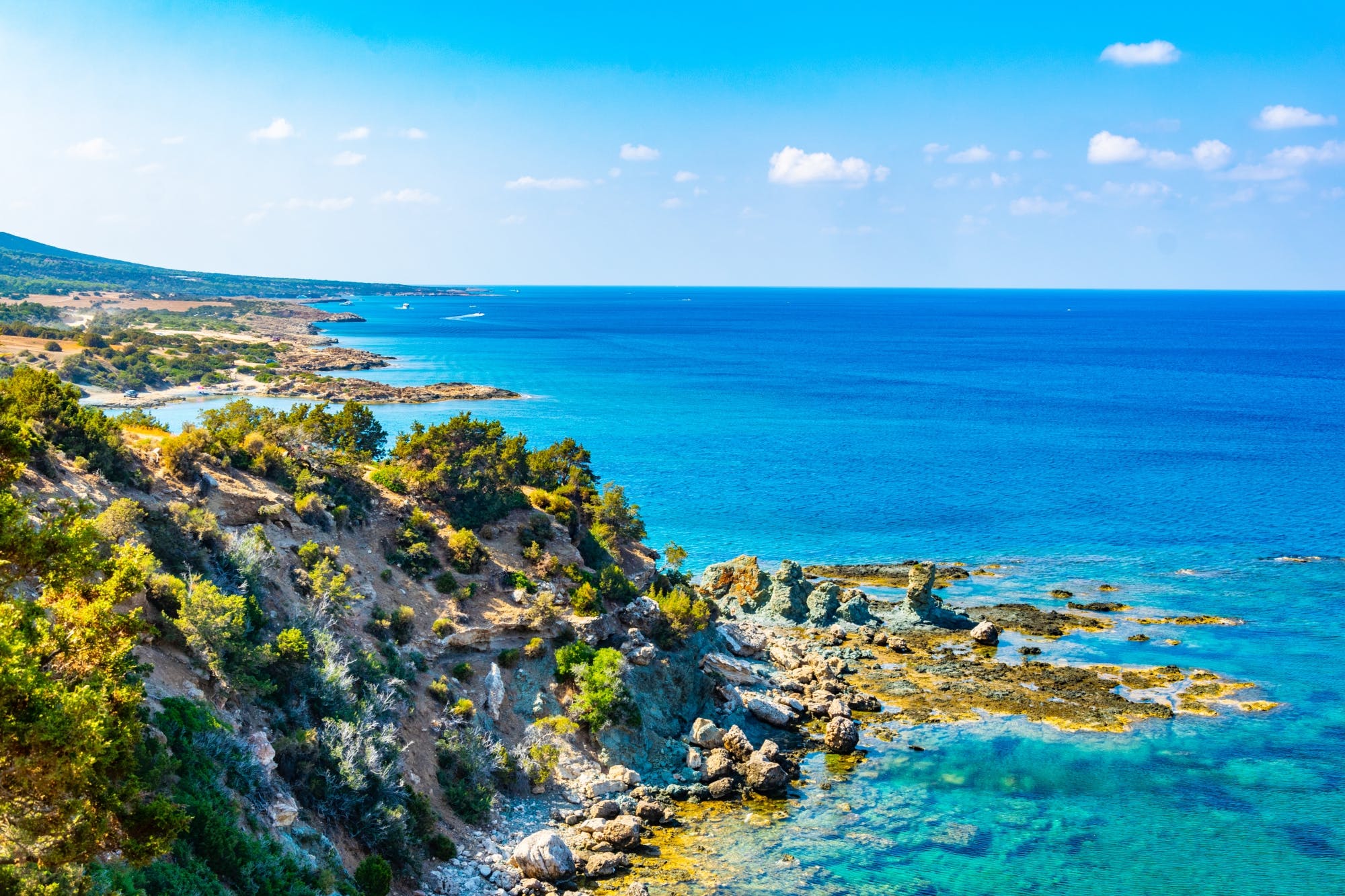 A scenic view of Akamas National Park's rugged coastline, turquoise waters, and rocky cliffs - a must-visit attraction and one of the top things to do in Cyprus for nature lovers.