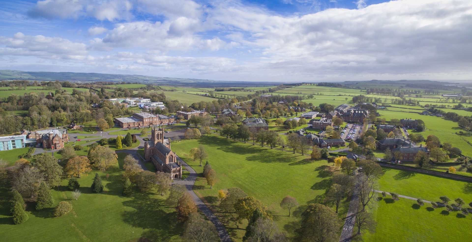 A photo of The Crichton Estate, a beautiful park in Dumfries, Scotland, featuring stunning gardens and architecture, once a hospital, now serving as a campus for the University of Glasgow.
